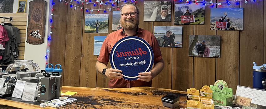 Red Beard's owner holding up Alumni owned sign.